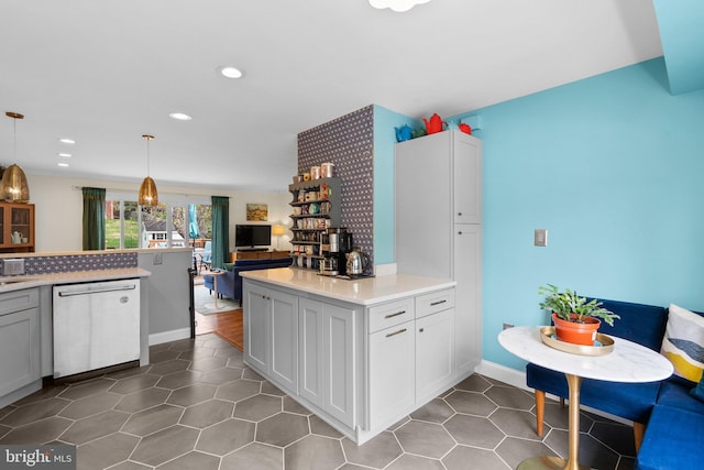 kitchen with decorative light fixtures, dishwasher, light countertops, dark tile patterned floors, and recessed lighting