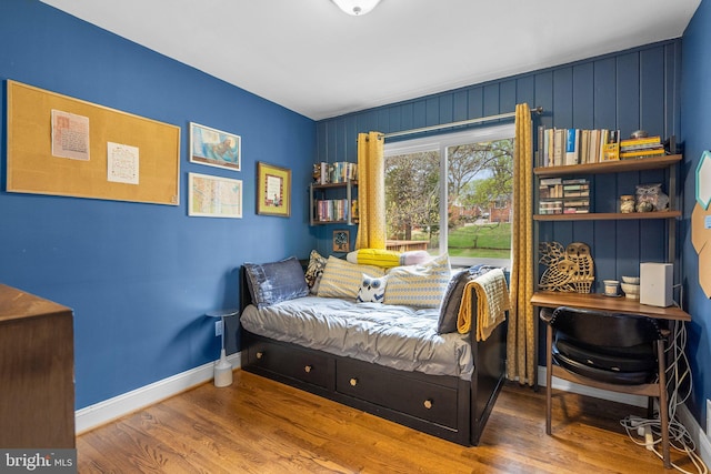 bedroom with baseboards and wood finished floors