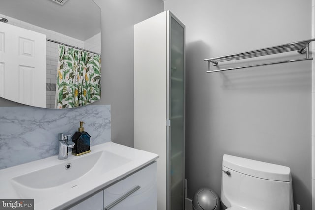 bathroom with toilet, curtained shower, vanity, and decorative backsplash