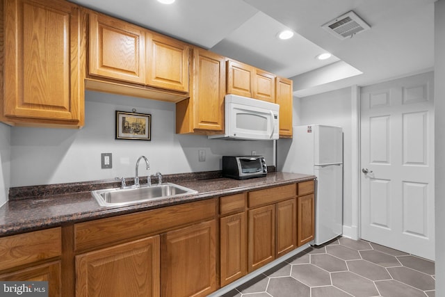 kitchen with recessed lighting, white appliances, a toaster, visible vents, and a sink