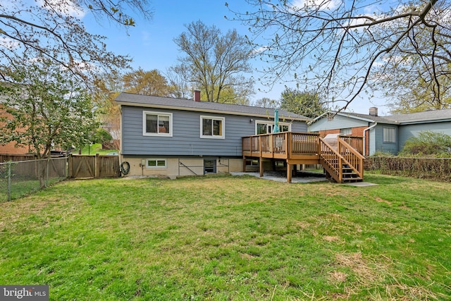 rear view of property with a fenced backyard, a wooden deck, a lawn, and a chimney