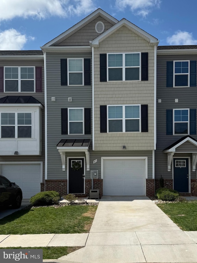 townhome / multi-family property featuring brick siding, an attached garage, and driveway