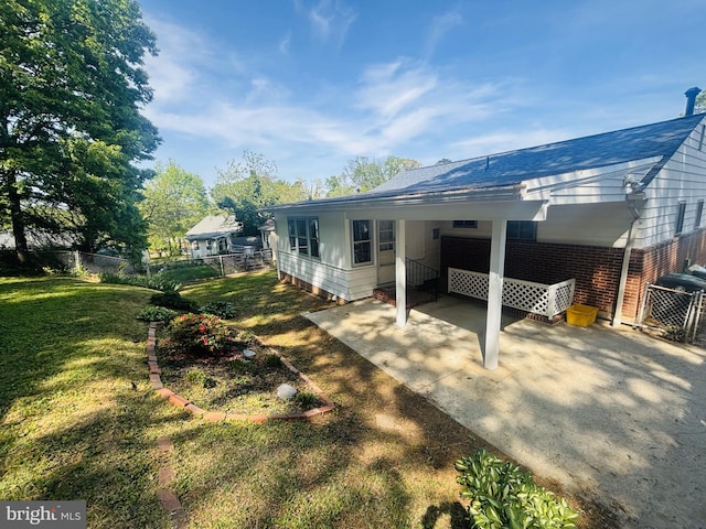 4714 Glenoak Rd, Hyattsville, MD 20784 - back of house featuring fence, brick siding, concrete driveway, a carport, and a yard