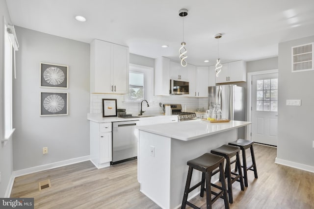 2116 R St NE, Washington, DC 20002 - kitchen with tasteful backsplash, a healthy amount of sunlight, a breakfast bar area, appliances with stainless steel finishes, and visible vents