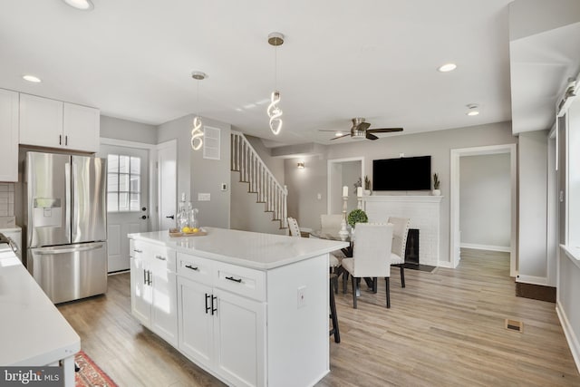 2116 R St NE, Washington, DC 20002 - kitchen with a ceiling fan, light wood-type flooring, stainless steel fridge, light countertops, and white cabinetry