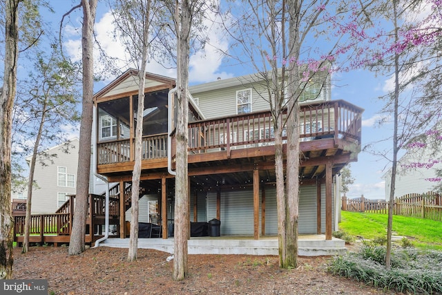 rear view of property featuring fence, a deck, a patio, and a sunroom