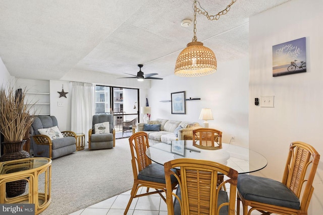 dining area with light tile patterned floors, a ceiling fan, light carpet, and a textured ceiling