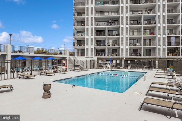 pool with fence and a patio