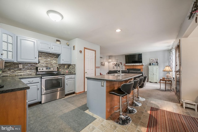 113 Fieldbrook, Magnolia, DE 19962 - kitchen with stainless steel range with electric stovetop, a kitchen breakfast bar, backsplash, a kitchen island with sink, and open floor plan