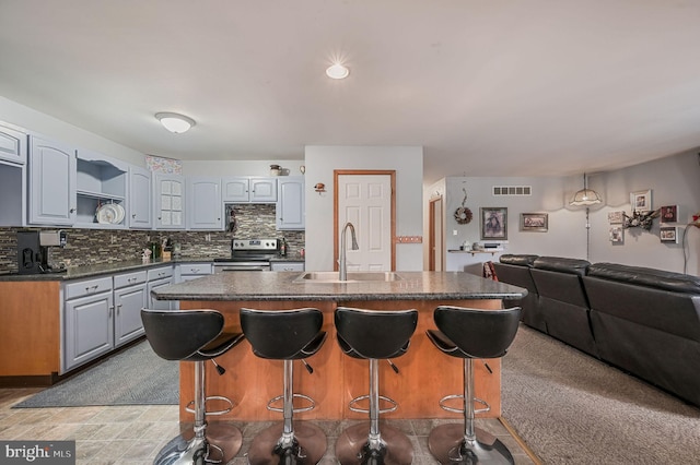 113 Fieldbrook, Magnolia, DE 19962 - kitchen featuring a sink, stainless steel electric stove, dark countertops, and a kitchen breakfast bar