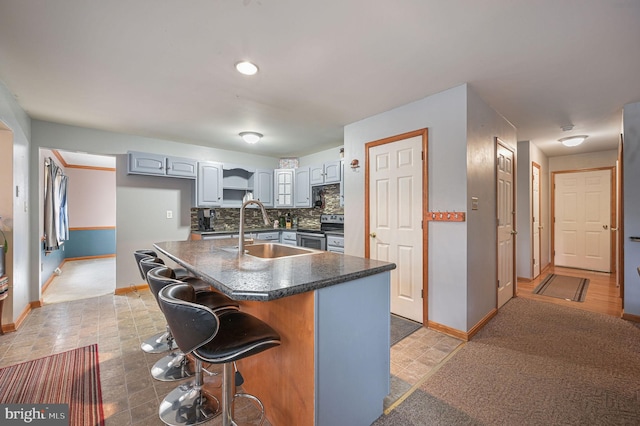 113 Fieldbrook, Magnolia, DE 19962 - kitchen featuring electric range, baseboards, dark countertops, a sink, and a breakfast bar