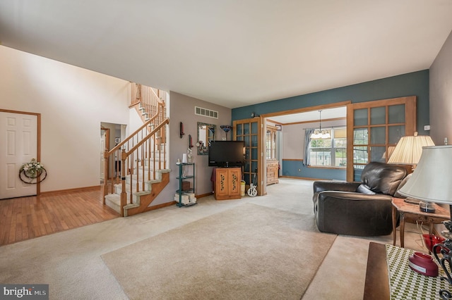 113 Fieldbrook, Magnolia, DE 19962 - carpeted living area with stairs, baseboards, and a chandelier