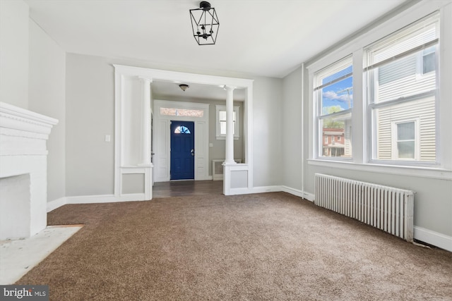 4011 Hayward Ave, Baltimore, MD 21215 - unfurnished living room with radiator heating unit, ornate columns, carpet flooring, and baseboards