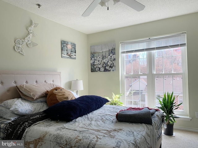 carpeted bedroom with a textured ceiling and ceiling fan