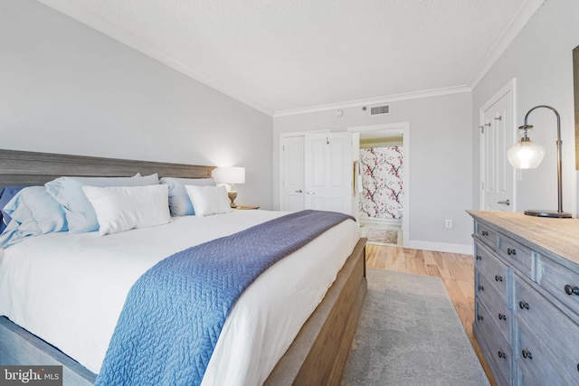 bedroom with baseboards, a textured ceiling, crown molding, light wood-style floors, and visible vents