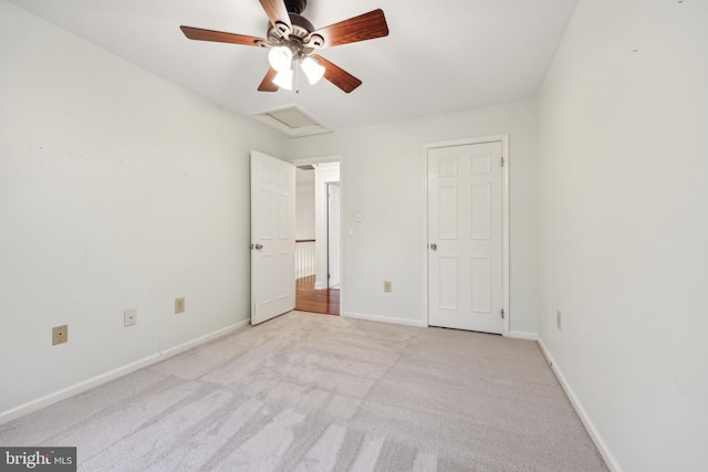 unfurnished bedroom featuring attic access, baseboards, a ceiling fan, and carpet floors