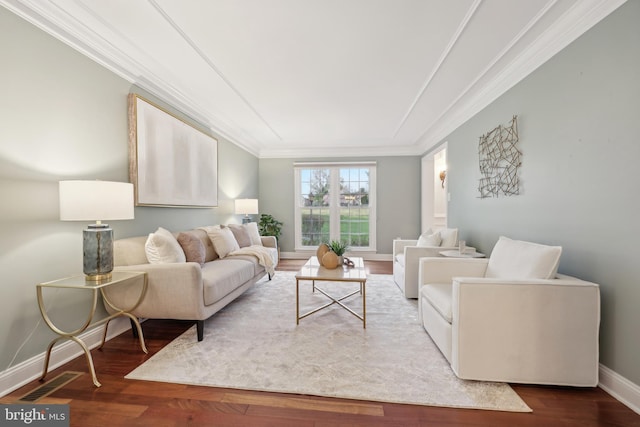 living area with ornamental molding, visible vents, baseboards, and wood finished floors