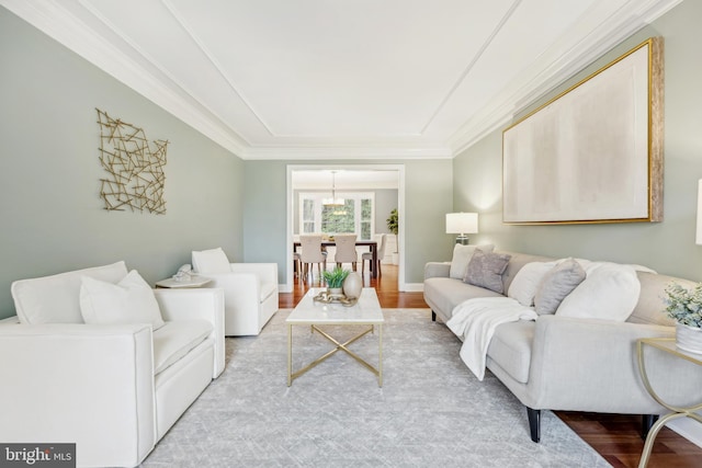 living room with crown molding, light wood finished floors, and baseboards