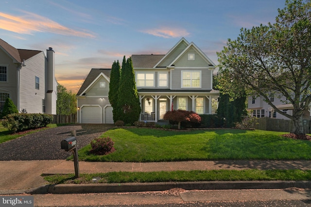 traditional-style house featuring fence, a porch, a yard, a garage, and gravel driveway