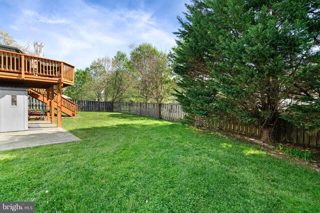 view of yard featuring stairs, a patio area, a wooden deck, and a fenced backyard