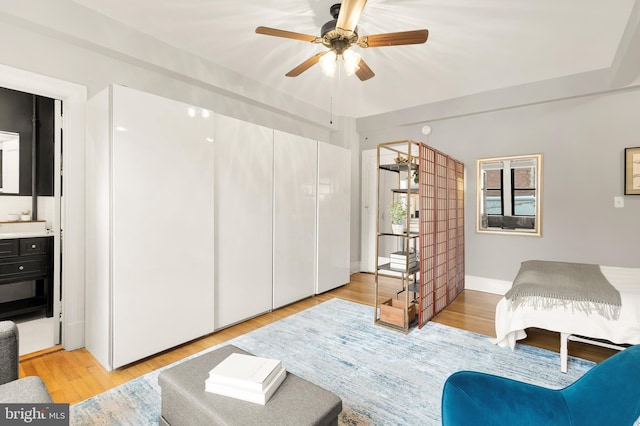 bedroom with ensuite bathroom and light wood finished floors