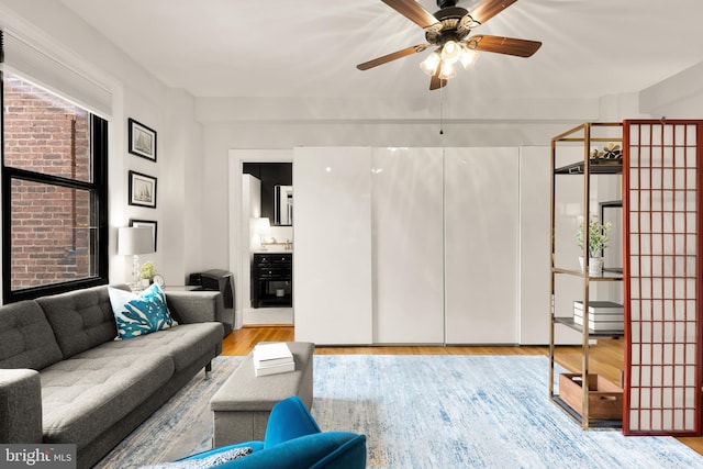 living room featuring a ceiling fan and wood finished floors