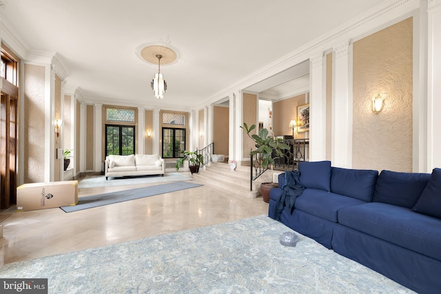 living area with a textured wall, ornamental molding, and marble finish floor