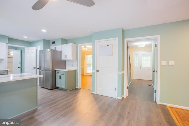 2409 Wood Stream Ct, Ellicott City, MD 21042 - kitchen with freestanding refrigerator, light countertops, ceiling fan, light wood finished floors, and white cabinets
