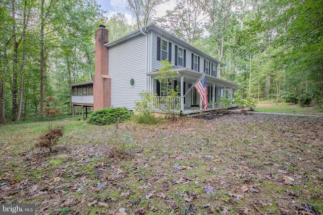 2409 Wood Stream Ct, Ellicott City, MD 21042 - view of front of home featuring a chimney, a porch, and a sunroom