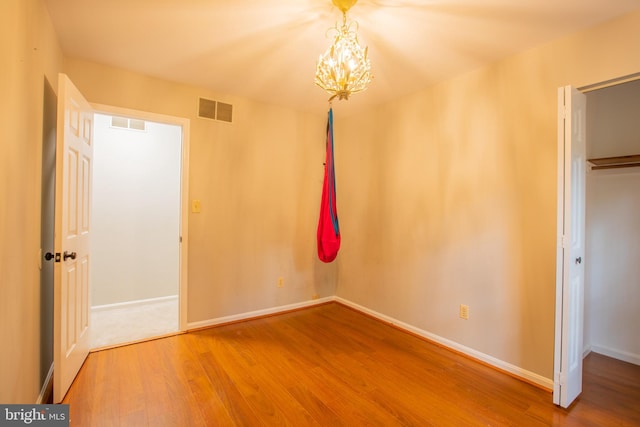 2409 Wood Stream Ct, Ellicott City, MD 21042 - unfurnished bedroom with wood finished floors, a chandelier, and baseboards