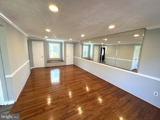 interior space with wood-type flooring, a textured ceiling, crown molding, and recessed lighting
