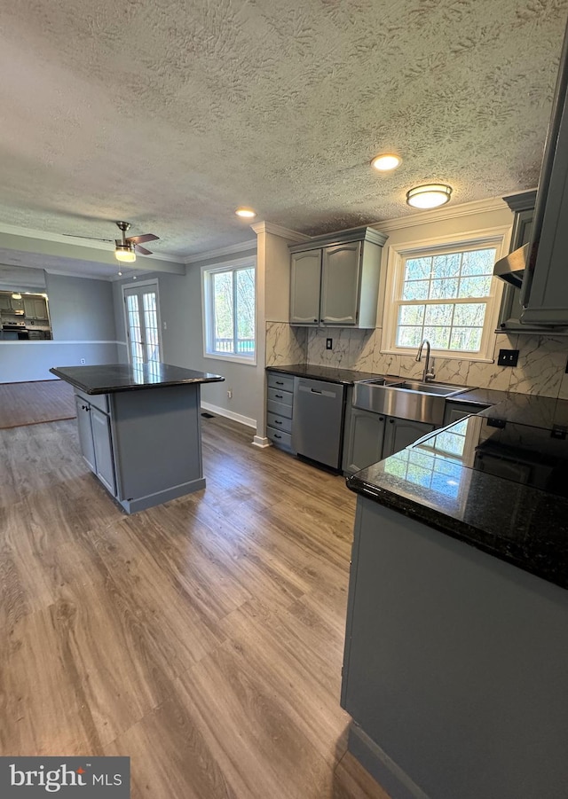 kitchen featuring dark countertops, dishwasher, gray cabinetry, and a sink