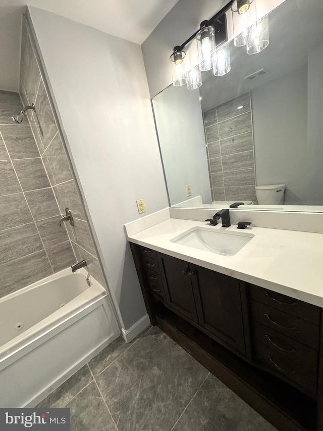 bathroom featuring toilet, shower / bathtub combination, visible vents, baseboards, and vanity