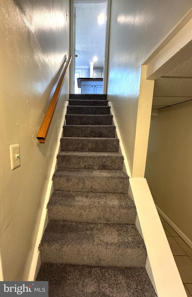 stairs featuring tile patterned floors and baseboards