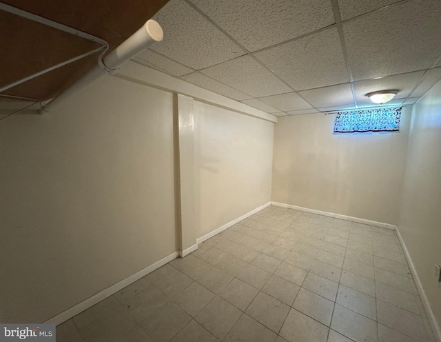 below grade area with a drop ceiling and baseboards