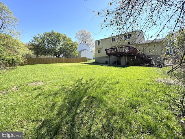view of yard with a wooden deck, stairs, and fence