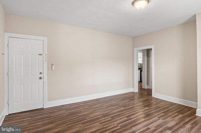 unfurnished room with wood finished floors and baseboards