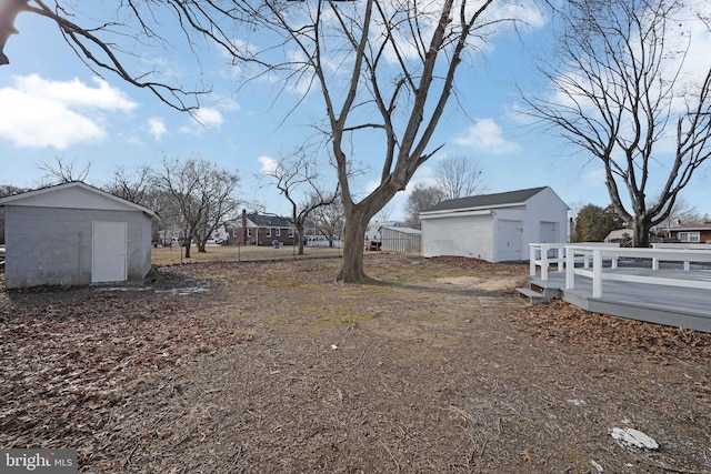 view of yard with an outbuilding, a storage unit, fence, and a detached garage