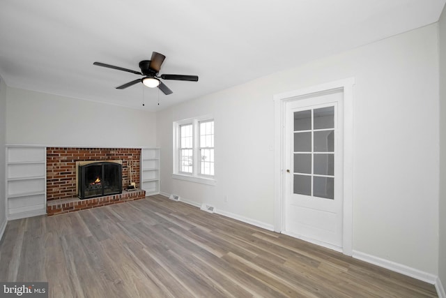 unfurnished living room featuring visible vents, baseboards, and wood finished floors