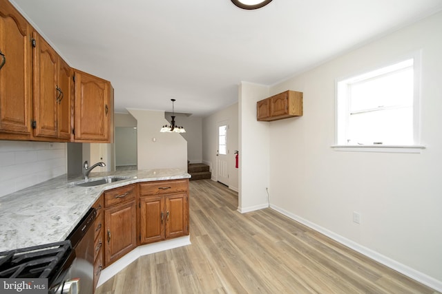 kitchen with a peninsula, light wood-style flooring, a sink, and brown cabinets