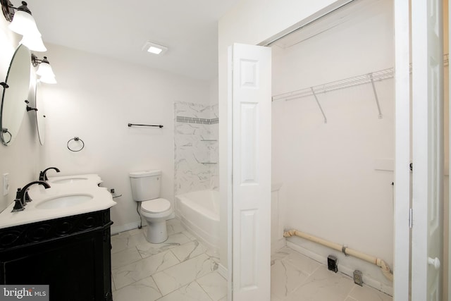 full bathroom with marble finish floor, double vanity, toilet, and a sink