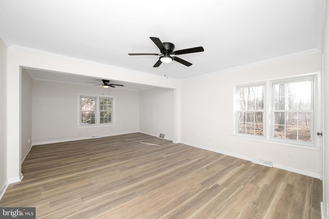 unfurnished room featuring ornamental molding, light wood-style floors, and visible vents