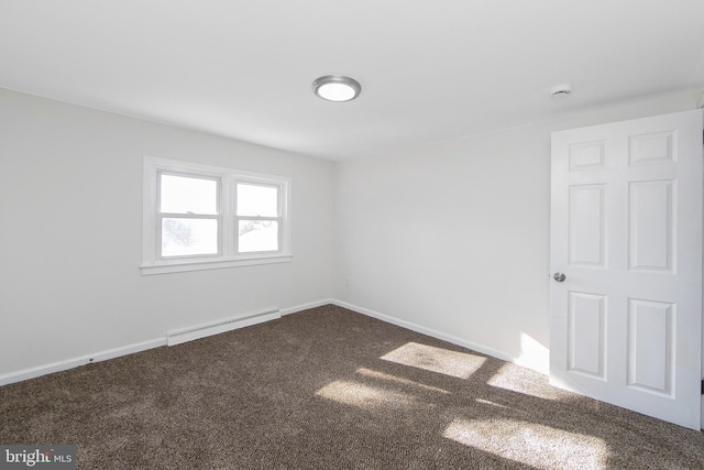 spare room with baseboards, baseboard heating, and dark colored carpet