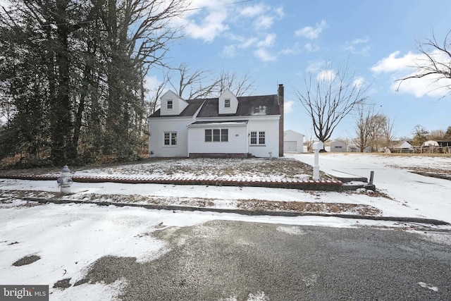 cape cod-style house featuring a chimney