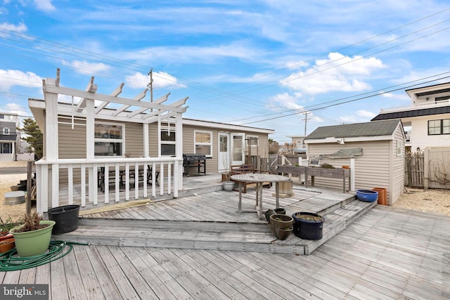 rear view of house featuring a storage shed, an outdoor structure, a pergola, and a wooden deck