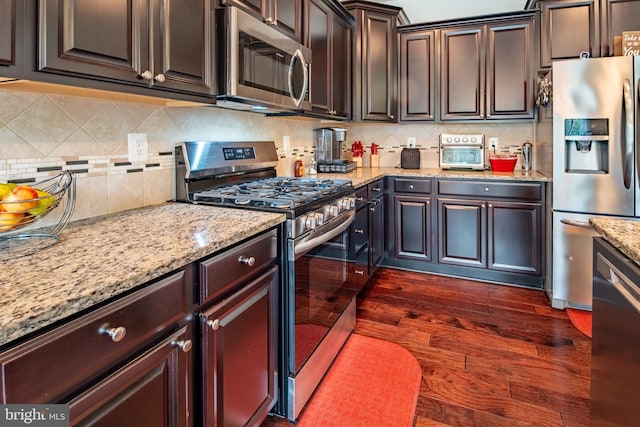kitchen featuring light stone countertops, appliances with stainless steel finishes, and decorative backsplash