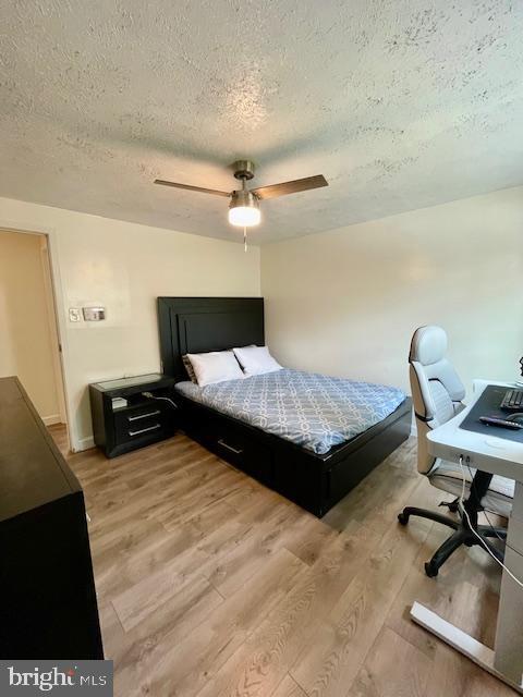 704 Pritchard Ln, Upper Marlboro, MD 20774 - bedroom featuring a textured ceiling, light wood-style flooring, and a ceiling fan