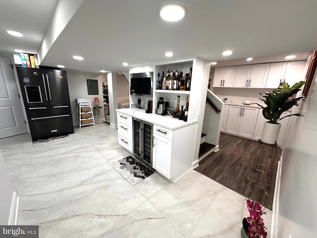 14427 Seneca Rd, Germantown, MD 20874 - kitchen featuring black fridge with ice dispenser, wine cooler, recessed lighting, white cabinetry, and light marble finish flooring