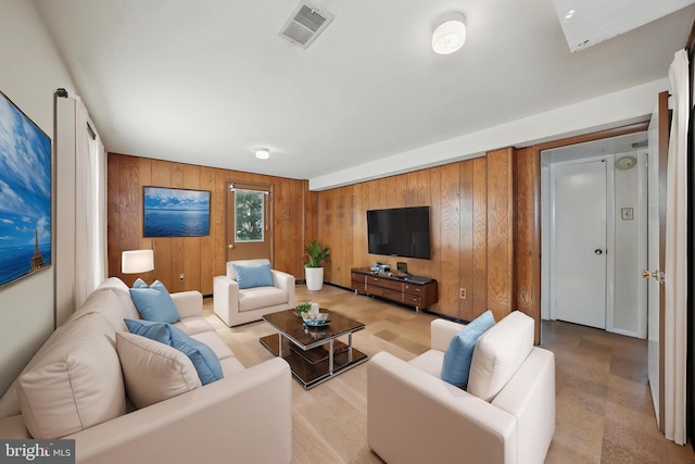 living room featuring visible vents and wood walls