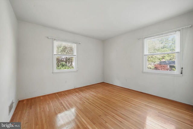 unfurnished room featuring visible vents and light wood-style flooring